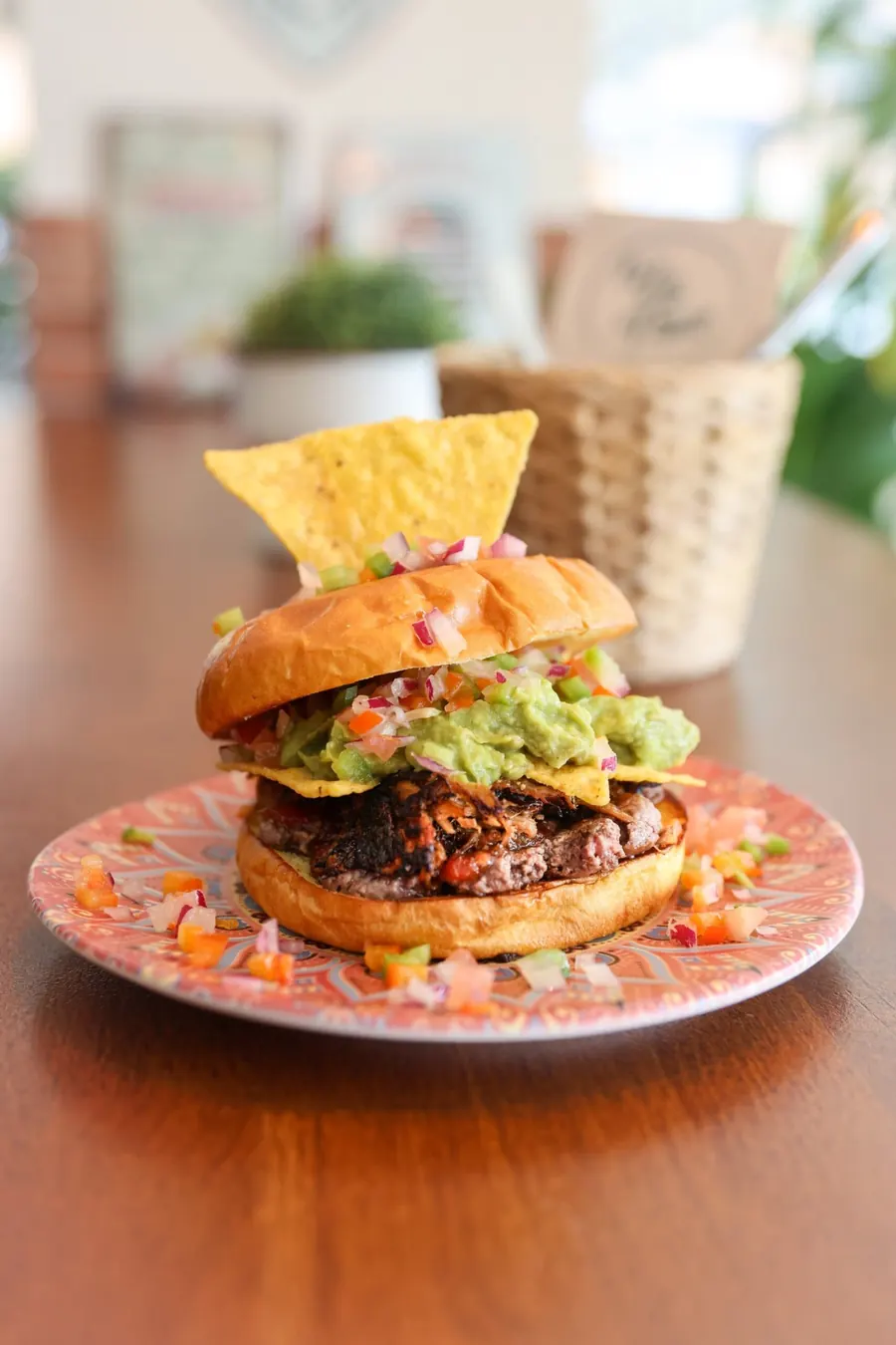 Burger, gekrönt mit Nachos und Guacamole
