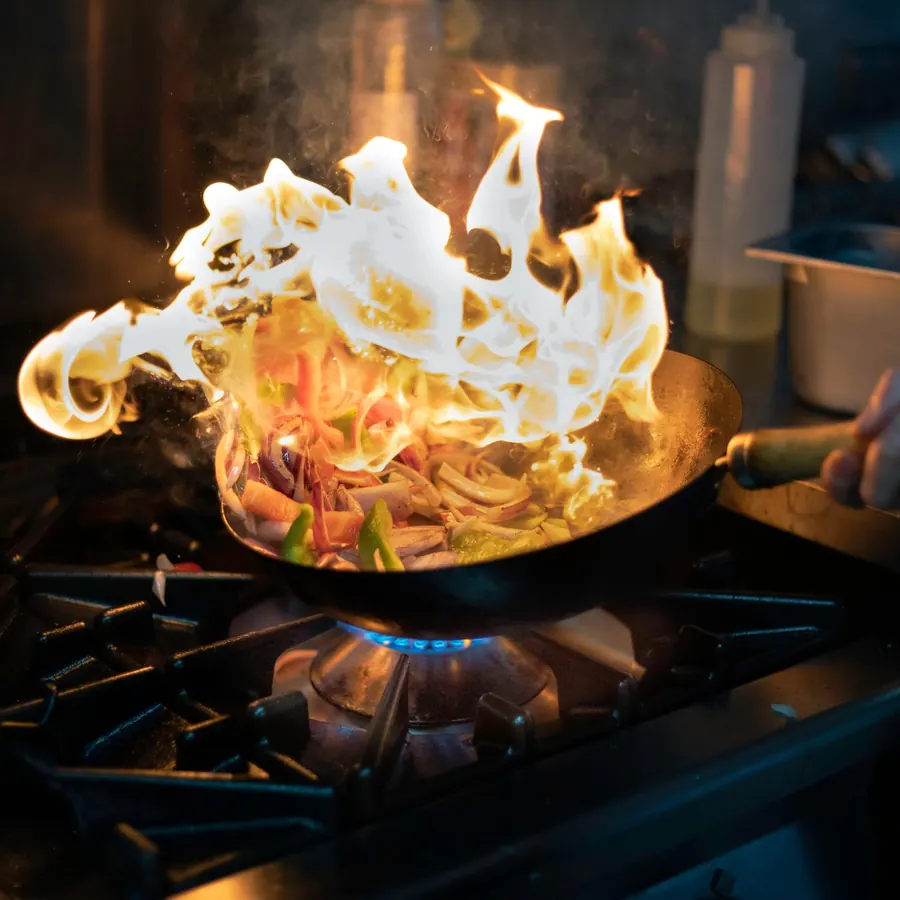Flambiertes Pfannengericht in der Küche