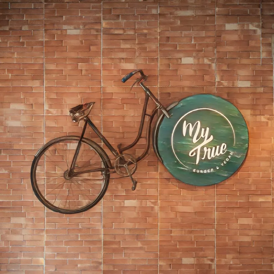 Das My-True-Logo an der Backsteinwand neben einem Fahrrad